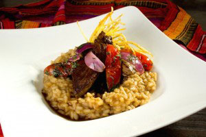 lomo saltado with onions and tomatoes and risotto at the base.